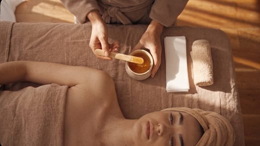 Warm sugar wax with a wooden spatula and cotton strips
